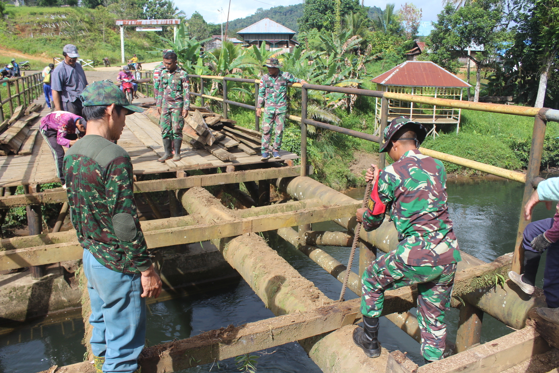 Satgas pamtas ri-mly yonarmed 5/pancagiri pos long ampung membantu perbaikan jembatan